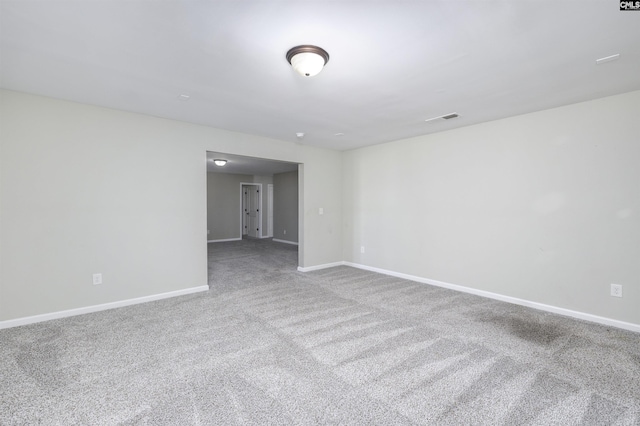 carpeted spare room featuring visible vents and baseboards