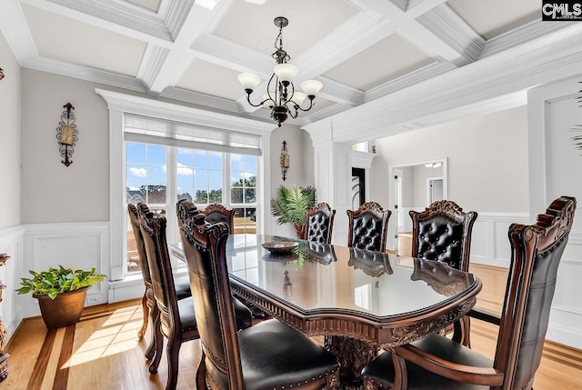 dining area featuring an inviting chandelier, beamed ceiling, and light wood-style floors