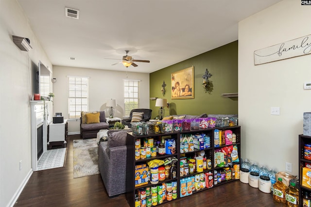 living room with visible vents, baseboards, a ceiling fan, and wood finished floors