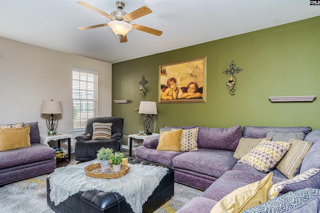 living room with baseboards and a ceiling fan