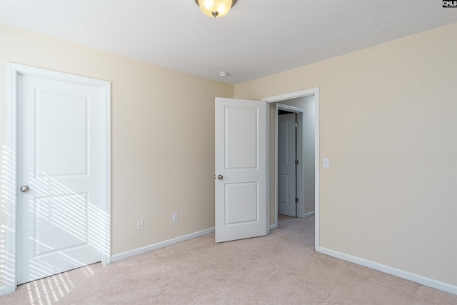 unfurnished bedroom with baseboards and light carpet