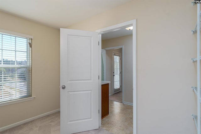 hall with a wealth of natural light and baseboards