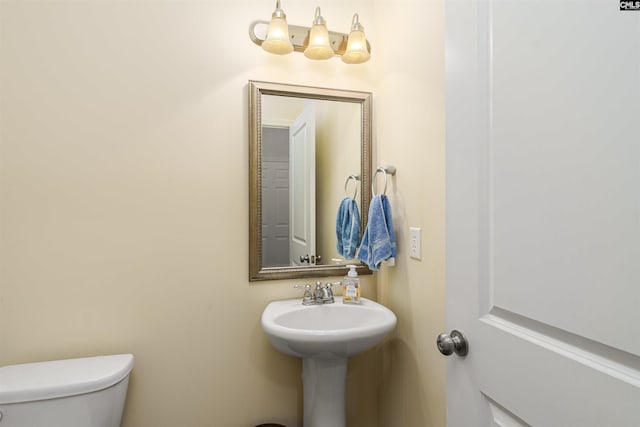 half bath featuring a sink and toilet