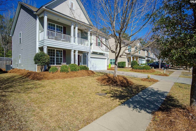 view of front facade featuring a front lawn, driveway, cooling unit, a garage, and a balcony