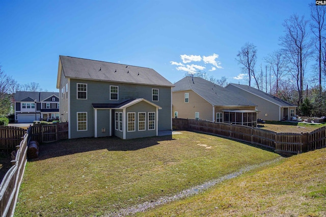 rear view of property featuring a lawn and a fenced backyard