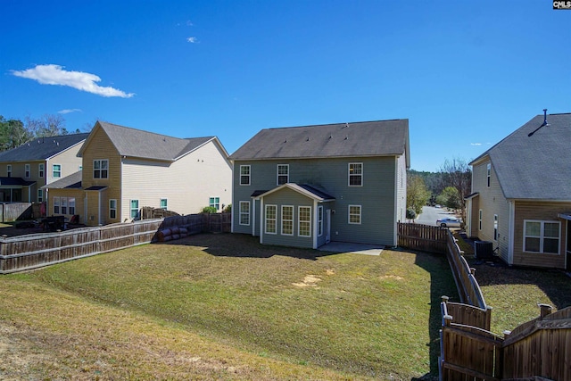 rear view of house featuring cooling unit, a fenced backyard, a residential view, a patio area, and a lawn