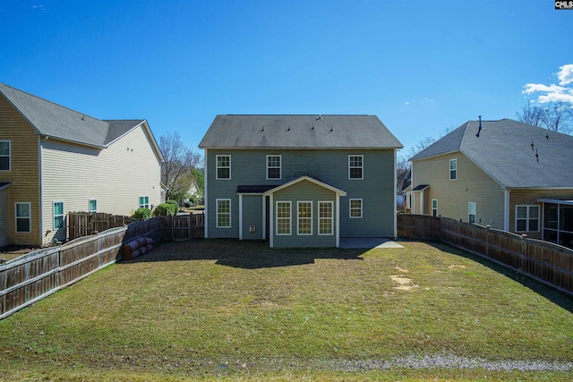 rear view of property featuring a fenced backyard and a yard