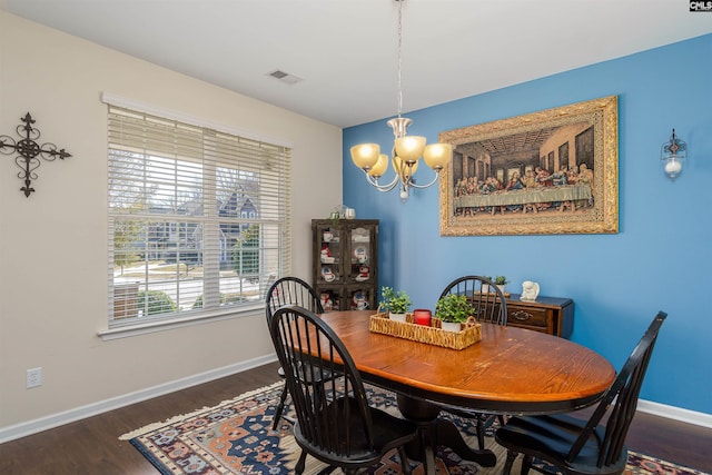 dining area featuring an inviting chandelier, wood finished floors, baseboards, and visible vents