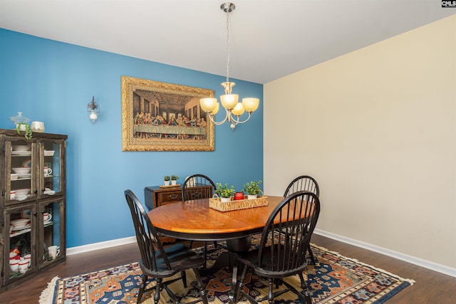 dining space with a notable chandelier, baseboards, and wood finished floors