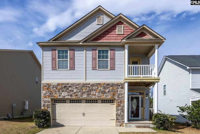 view of front facade featuring stone siding, a garage, driveway, and a balcony