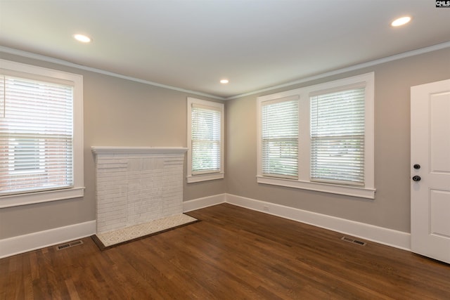 unfurnished room featuring dark wood finished floors, visible vents, plenty of natural light, and crown molding