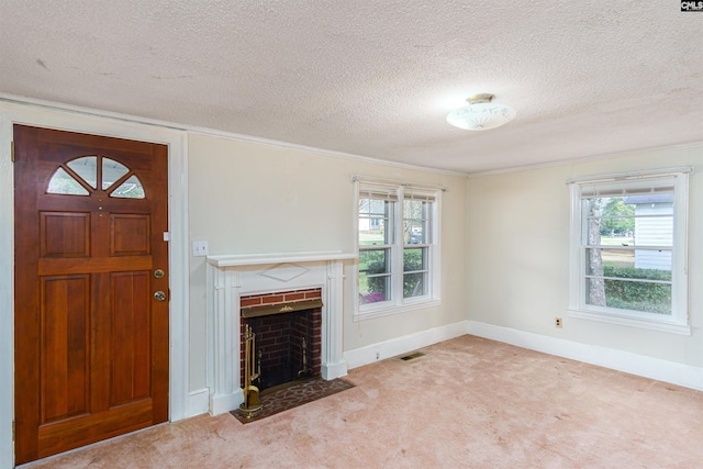 entrance foyer with visible vents, a fireplace, baseboards, and carpet floors