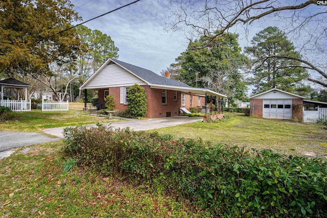 exterior space with brick siding, fence, a lawn, an outbuilding, and driveway