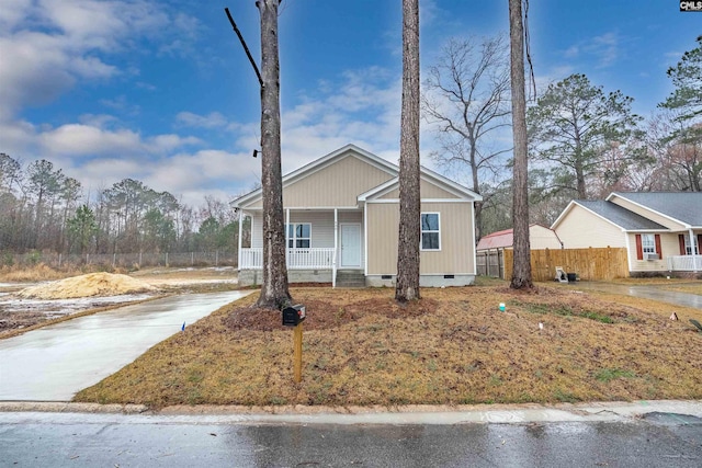 view of front of house featuring crawl space, a porch, driveway, and fence