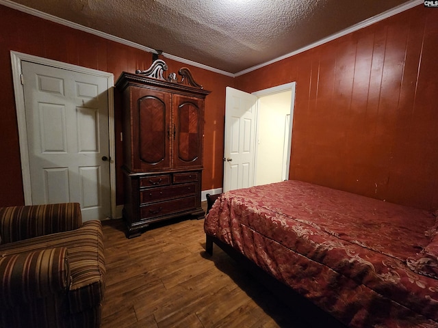 bedroom with a textured ceiling, wood finished floors, and ornamental molding