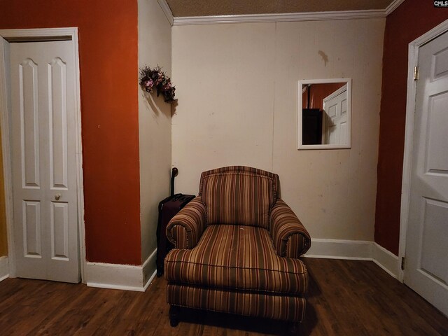 sitting room featuring baseboards, wood finished floors, and crown molding