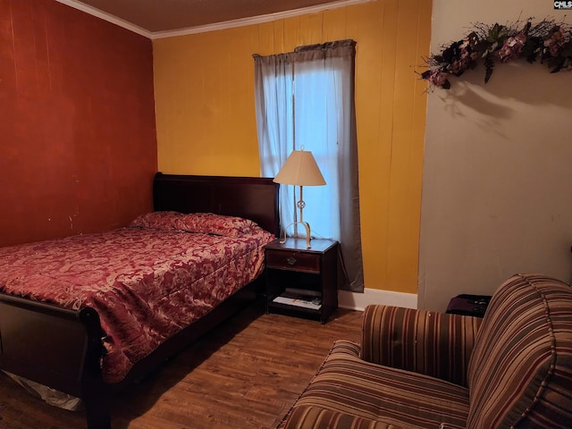 bedroom with wood finished floors, baseboards, wood walls, and ornamental molding