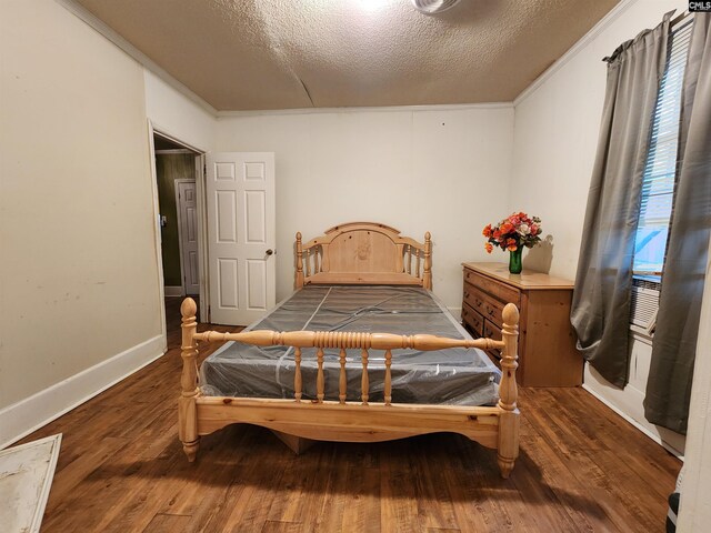 bedroom featuring a textured ceiling, crown molding, and wood finished floors