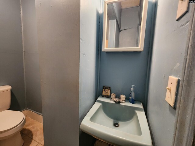 bathroom with a sink, toilet, and tile patterned flooring