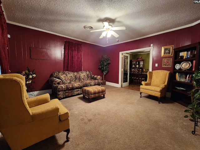 living area featuring a textured ceiling, carpet flooring, visible vents, and ornamental molding