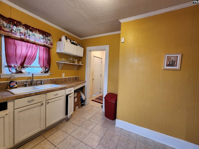 kitchen featuring ornamental molding, a sink, open shelves, a textured ceiling, and light tile patterned floors