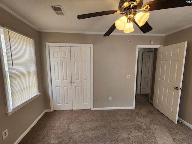 unfurnished bedroom featuring crown molding, baseboards, visible vents, and a closet