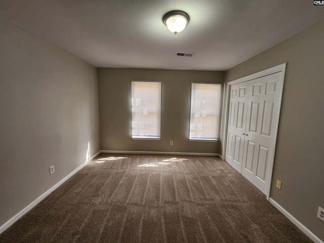 unfurnished bedroom with visible vents, baseboards, and carpet flooring