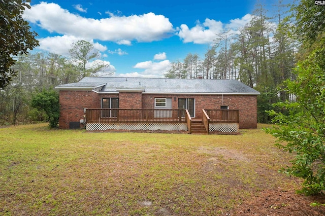 rear view of house with a wooden deck, brick siding, and a lawn