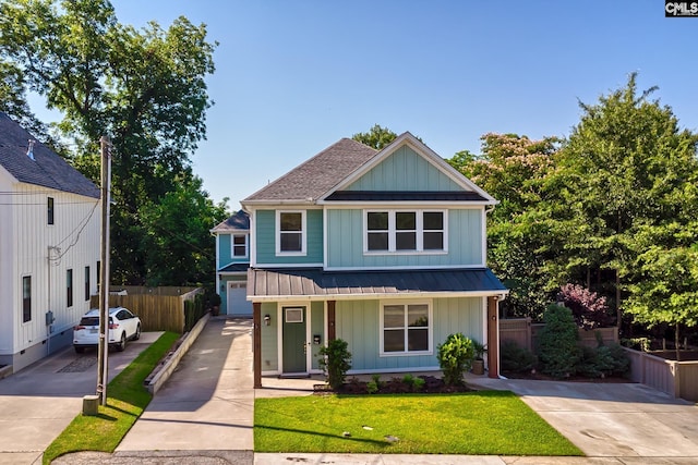 view of front of property featuring fence, a standing seam roof, concrete driveway, board and batten siding, and metal roof