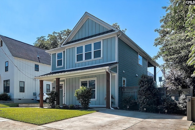 view of front of house featuring a standing seam roof, a porch, fence, board and batten siding, and metal roof