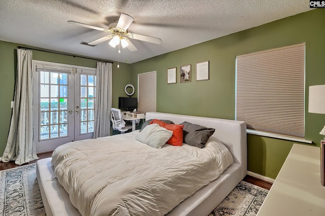 bedroom featuring french doors, a textured ceiling, ceiling fan, and wood finished floors