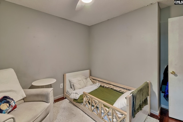 bedroom featuring ceiling fan, baseboards, and wood finished floors