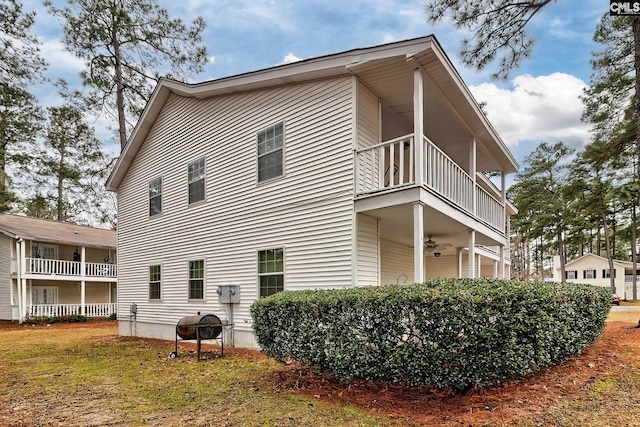 view of home's exterior with a balcony and a ceiling fan