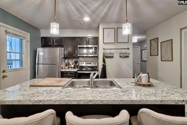 kitchen featuring a sink, stainless steel appliances, a breakfast bar area, and light countertops