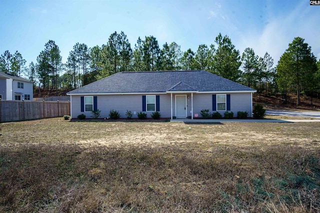 ranch-style house featuring a front yard and fence