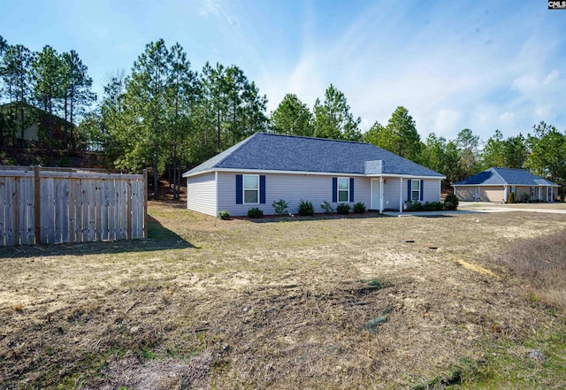 ranch-style home featuring a front lawn and fence