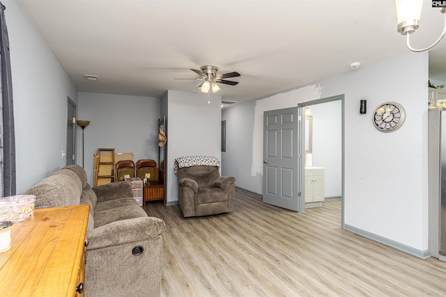 living area featuring light wood finished floors, visible vents, baseboards, and a ceiling fan