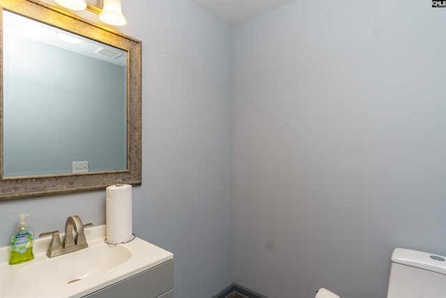 half bathroom featuring visible vents, toilet, and vanity