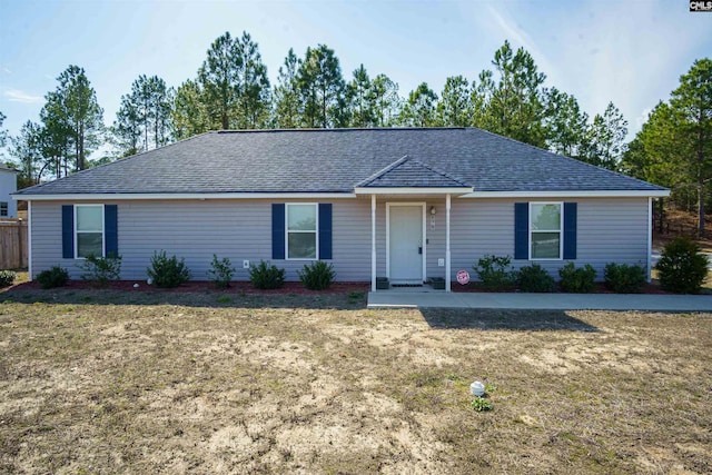 ranch-style house featuring a front yard and a shingled roof