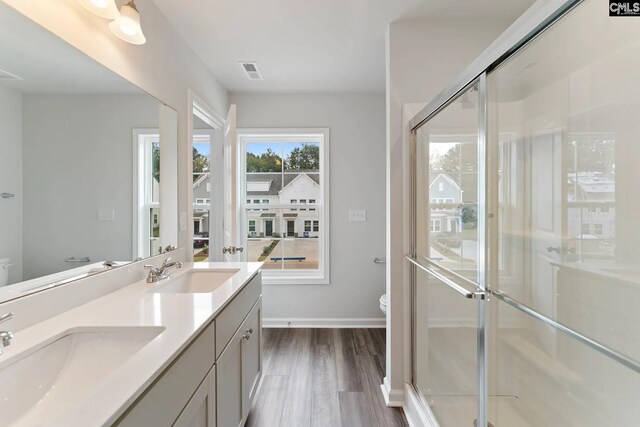 bathroom featuring a sink, toilet, and a stall shower
