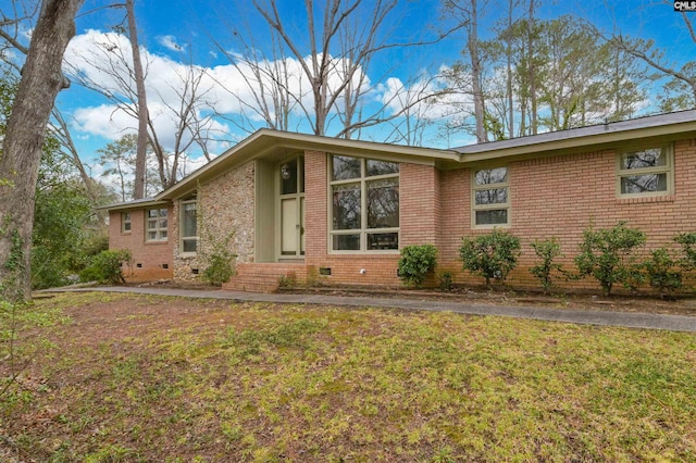 view of property exterior featuring crawl space, a lawn, and brick siding