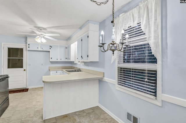 kitchen featuring visible vents, light countertops, white cabinets, a ceiling fan, and a sink