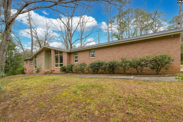 view of property exterior featuring brick siding, crawl space, and a yard