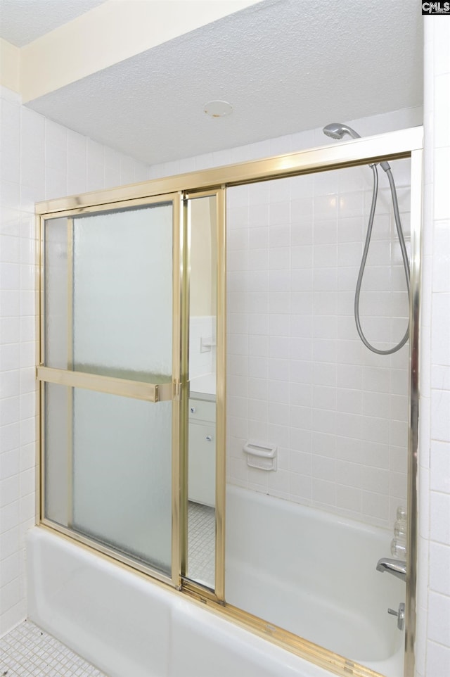 full bath with a textured ceiling and shower / bath combination with glass door