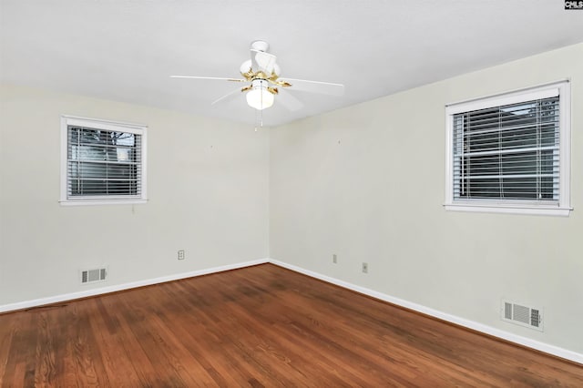 unfurnished room featuring visible vents, baseboards, wood finished floors, and a ceiling fan