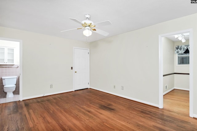 unfurnished room with wood finished floors, baseboards, and ceiling fan