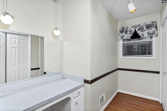 bathroom featuring vanity, wood finished floors, visible vents, and baseboards