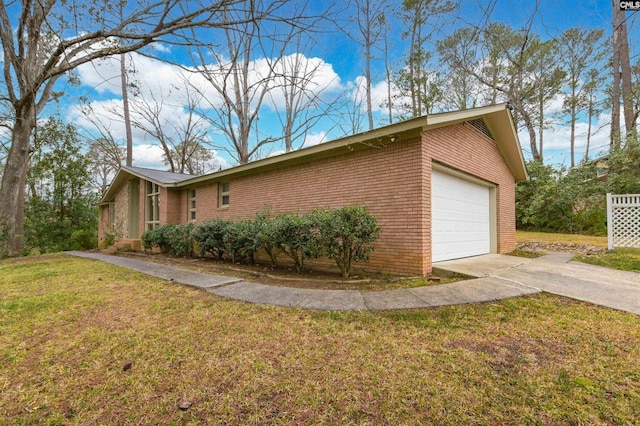 view of side of home with a garage, a yard, and brick siding