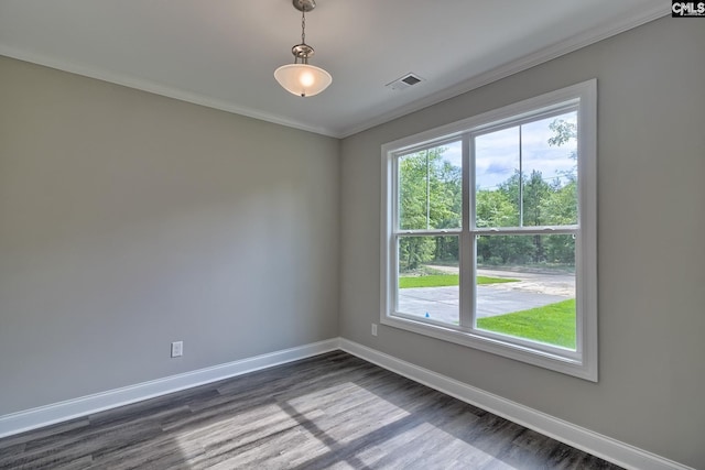 spare room featuring dark wood finished floors, crown molding, baseboards, and visible vents