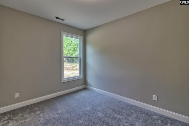 unfurnished room featuring carpet flooring, visible vents, and baseboards